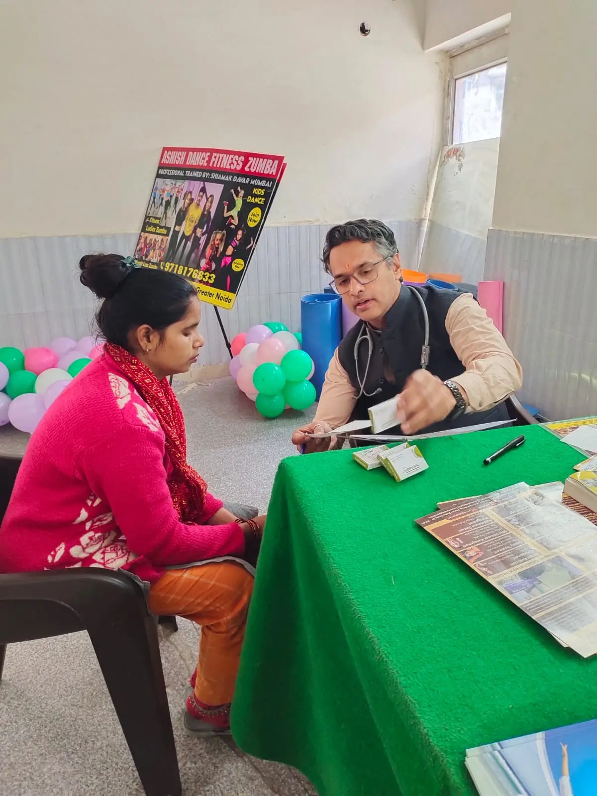 Dr. Dinesh Sharma explaining Ayurvedic recommendations to a camp visitor