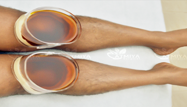 Janu Vasti traditional oil therapy applied around the knees